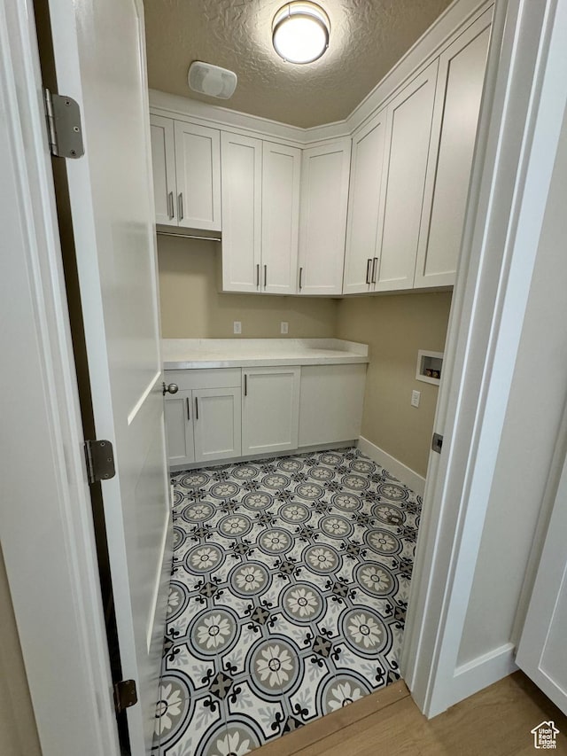 1273 W Hendrix St Unit 145, Riverton, UT 84065 - laundry room featuring cabinets, hookup for a washing machine, a textured ceiling, and light tile patterned floors