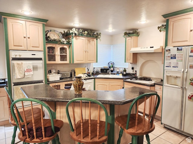 8298 S Arlington Ct, West Jordan, UT 84088 - kitchen with sink, white appliances, a kitchen island, a kitchen breakfast bar, and light tile patterned flooring