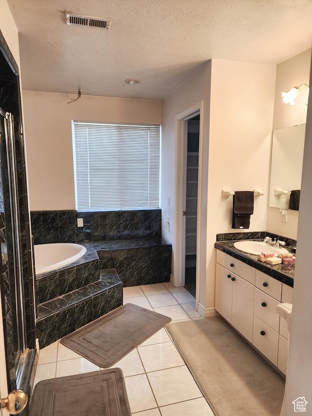 8298 S Arlington Ct, West Jordan, UT 84088 - bathroom with vanity, tile patterned flooring, a textured ceiling, and tiled tub