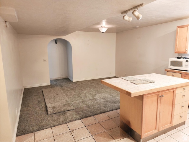 8298 S Arlington Ct, West Jordan, UT 84088 - kitchen featuring rail lighting, a center island, light brown cabinetry, tile countertops, and light colored carpet