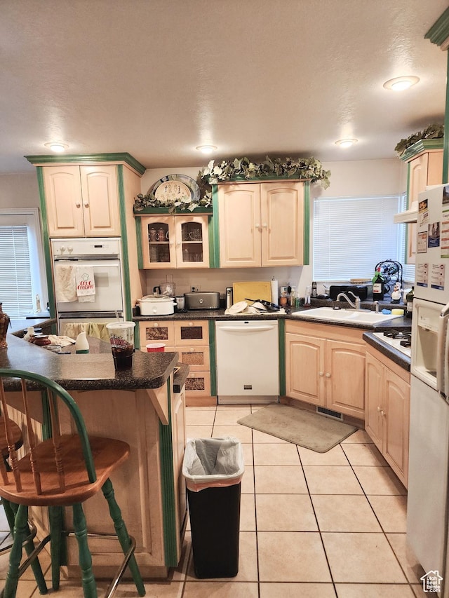 8298 S Arlington Ct, West Jordan, UT 84088 - kitchen featuring sink, white appliances, a breakfast bar area, and light tile patterned floors