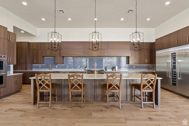 2015 S Pinnacle Cir, St George, UT 84790 - kitchen with a kitchen island with sink, pendant lighting, a breakfast bar area, and stainless steel appliances