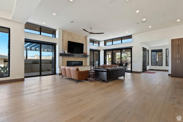 2015 S Pinnacle Cir, St George, UT 84790 - living room featuring a healthy amount of sunlight, a fireplace, light hardwood / wood-style floors, and a high ceiling
