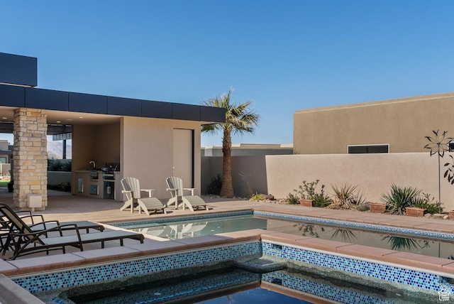 2015 S Pinnacle Cir, St George, UT 84790 - view of swimming pool with a hot tub, a patio, and exterior kitchen