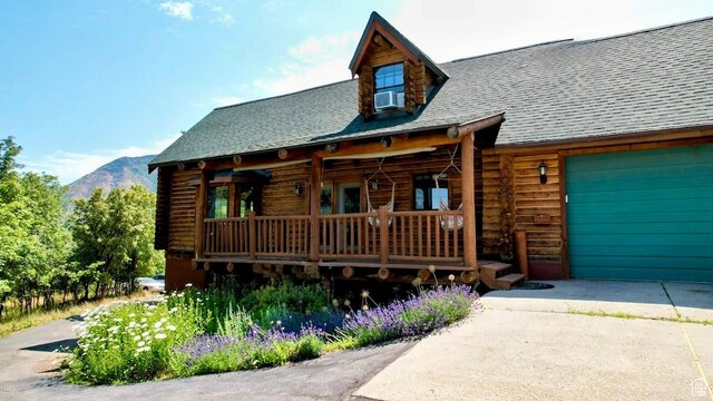 485 S Woodland Hills Dr, Woodland Hills, UT 84653 - cabin featuring log siding, a mountain view, concrete driveway, a shingled roof, and a garage