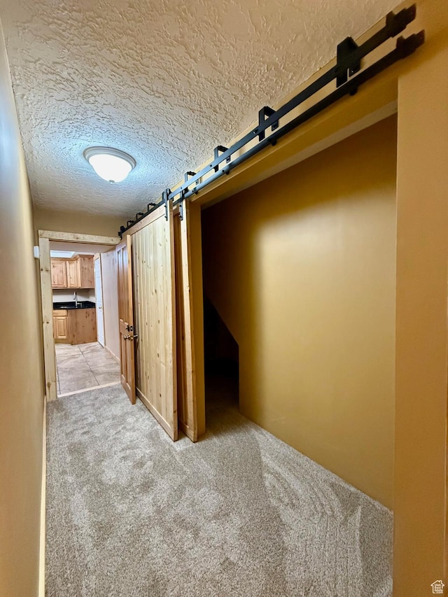 485 S Woodland Hills Dr, Woodland Hills, UT 84653 - corridor with a barn door, a textured ceiling, and light colored carpet