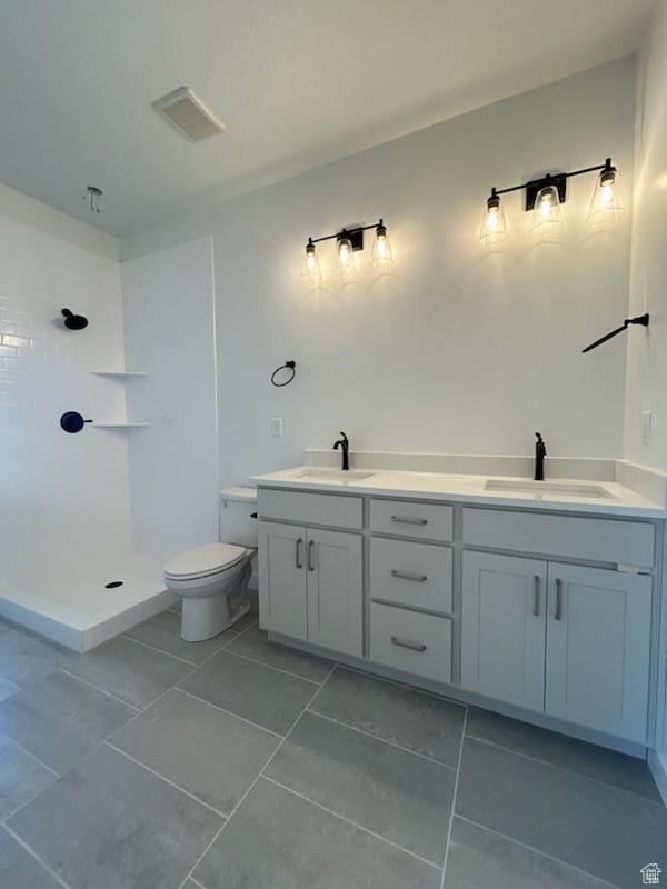 full bathroom with a shower, toilet, tile patterned floors, and double vanity