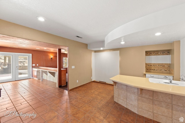 kitchen featuring sink, french doors, and a textured ceiling