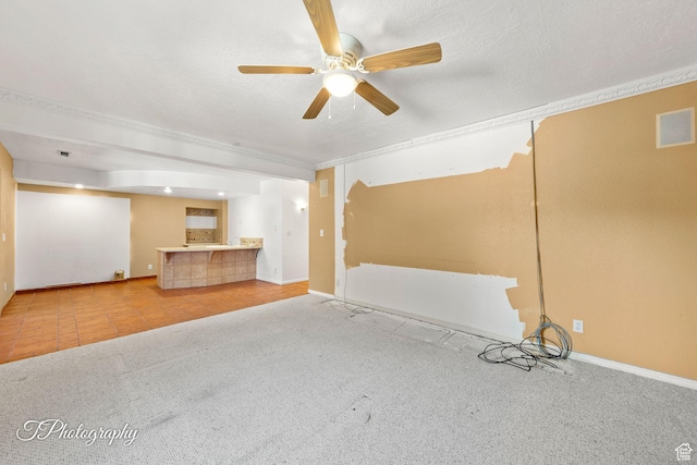 interior space with ceiling fan, light colored carpet, and a textured ceiling