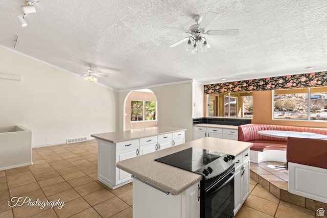kitchen featuring white cabinetry, black range with electric stovetop, and a kitchen island