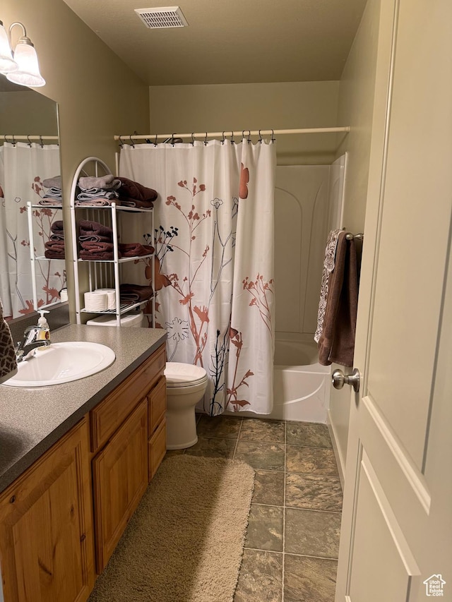 2044 N Evans Cove Loop W, Layton, UT 84041 - full bath featuring visible vents, vanity, toilet, shower / bathtub combination with curtain, and stone finish floor