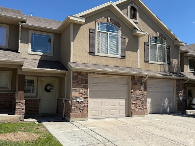multi unit property featuring an attached garage, concrete driveway, and stucco siding