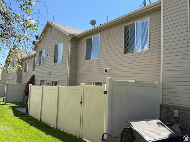 2044 N Evans Cove Loop W, Layton, UT 84041 - view of home's exterior with a lawn, fence, and a gate