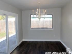 4548 W 4695 S, West Valley City, UT 84120 - unfurnished dining area with a chandelier, wood finished floors, and baseboards