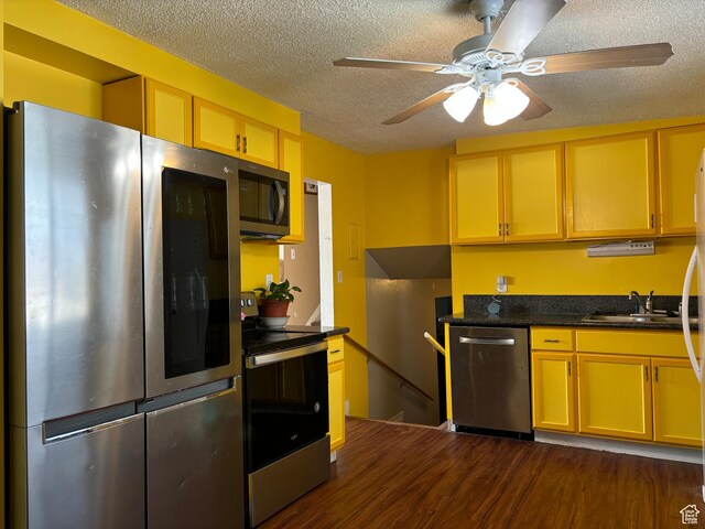 4548 W 4695 S, West Valley City, UT 84120 - kitchen with a textured ceiling, ceiling fan, appliances with stainless steel finishes, dark countertops, and dark wood finished floors
