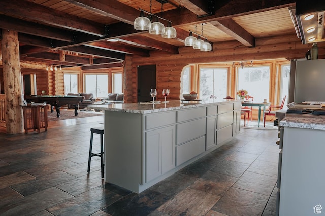 kitchen featuring beamed ceiling, billiards, wooden ceiling, and stone tile floors