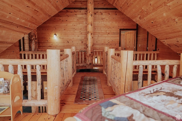 bedroom featuring wooden walls, wood-type flooring, vaulted ceiling, and wood ceiling