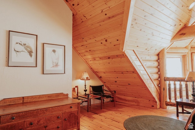living area with rustic walls, wooden ceiling, light wood finished floors, and lofted ceiling