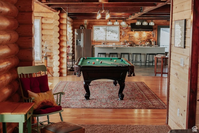 game room with log walls, billiards, and wood finished floors