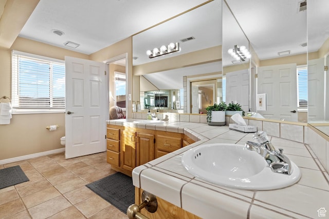 bathroom with toilet, vanity, tile patterned floors, and visible vents