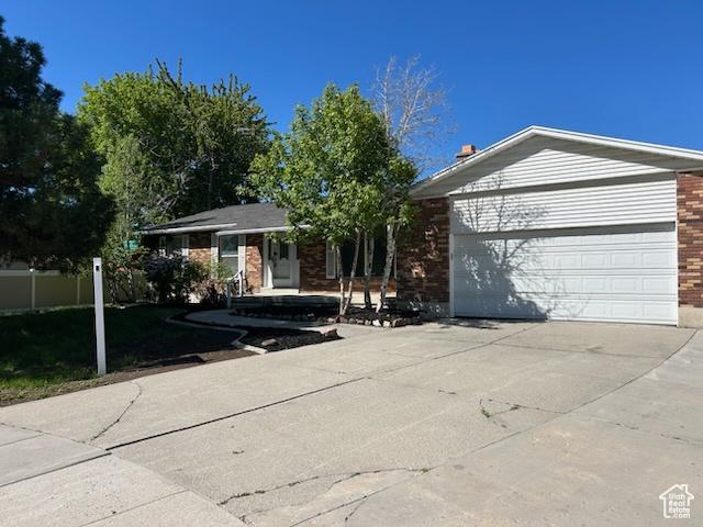 7548 S 3270 W, West Jordan, UT 84084 - ranch-style home with concrete driveway, brick siding, and an attached garage