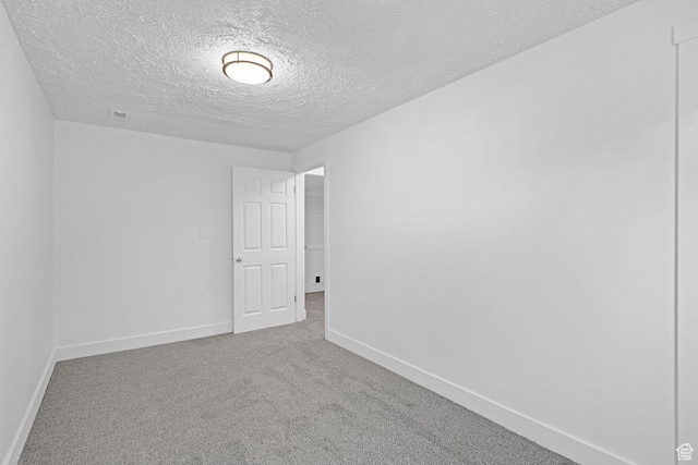 empty room with a textured ceiling and carpet
