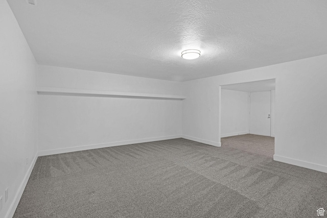 carpeted empty room featuring a textured ceiling