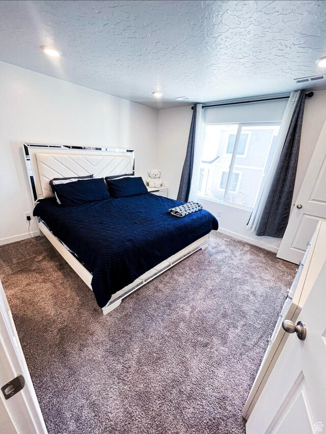 bedroom with a textured ceiling and carpet flooring