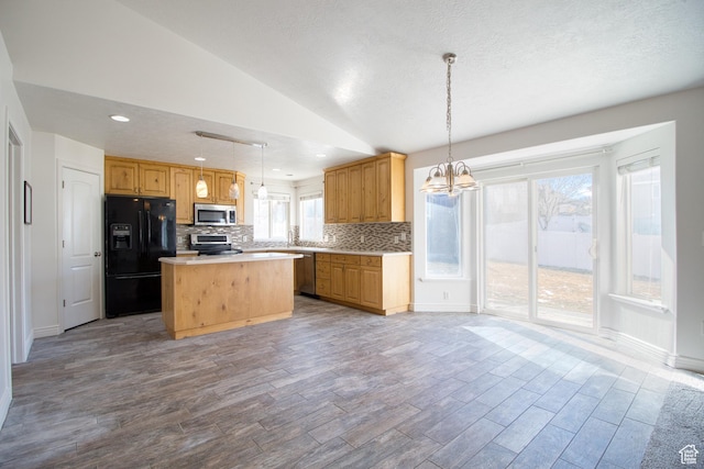 1247 S Alpine Dr, Saratoga Springs, UT 84045 - kitchen with appliances with stainless steel finishes, decorative backsplash, a chandelier, vaulted ceiling, and wood finished floors