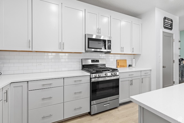 11283 S Willow Walk Dr W, South Jordan, UT 84009 - kitchen with stainless steel appliances, light wood finished floors, light countertops, and decorative backsplash