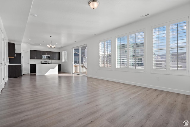 621 W 950 S, Springville, UT 84663 - unfurnished living room featuring visible vents, light wood-style flooring, recessed lighting, baseboards, and a chandelier