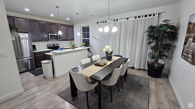 dining space featuring light wood finished floors, baseboards, and recessed lighting