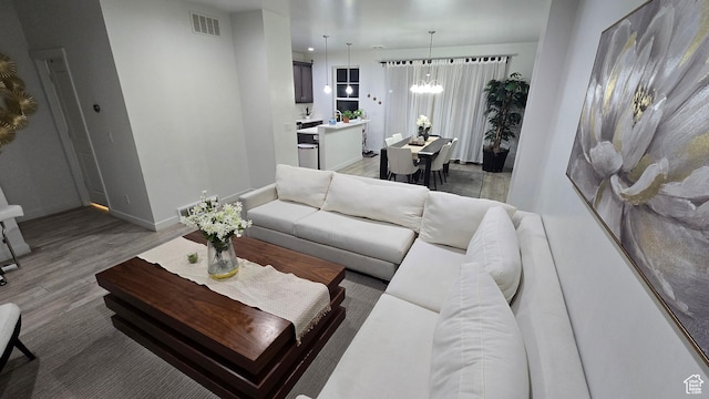 5343 W Big Sur Dr, South Jordan, UT 84009 - living room featuring baseboards, wood finished floors, visible vents, and a notable chandelier