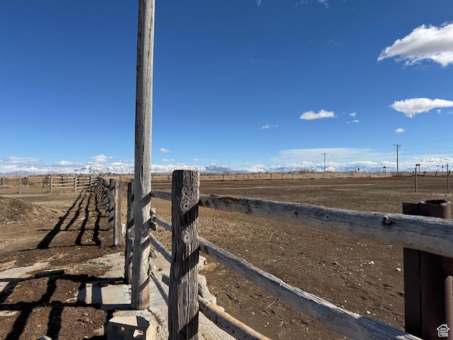 view of yard with fence and a rural view