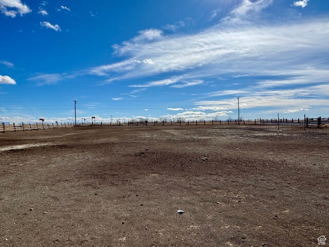 view of yard with fence and a rural view
