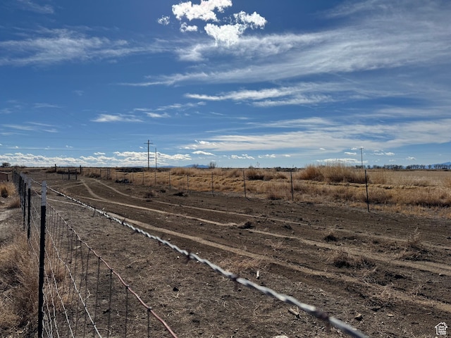view of yard with fence and a rural view