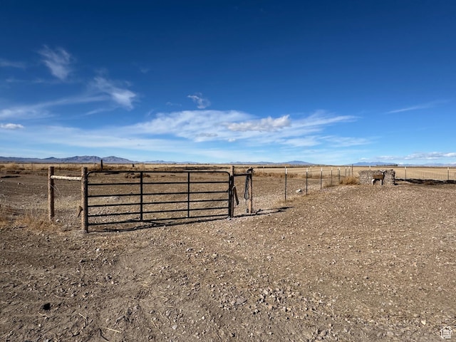 view of yard featuring a mountain view, fence, and a rural view