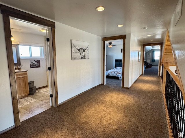 hallway with recessed lighting, baseboards, and light carpet