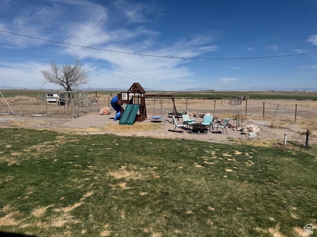 view of playground featuring a lawn and fence