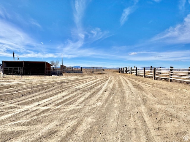 view of yard featuring an exterior structure, an outbuilding, a rural view, and fence