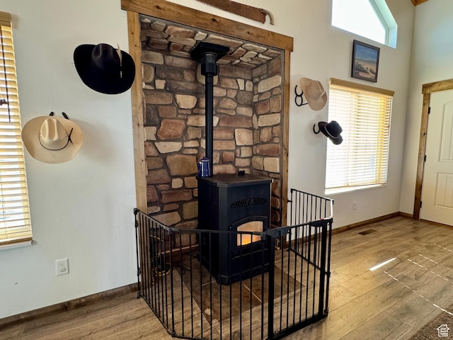 details with baseboards, a wood stove, wood finished floors, and visible vents