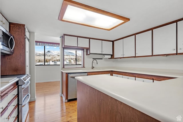 241 N Vine St W Unit 1101E, Salt Lake City, UT 84103 - kitchen featuring sink, light hardwood / wood-style flooring, white cabinets, and appliances with stainless steel finishes