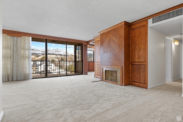 241 N Vine St W Unit 1101E, Salt Lake City, UT 84103 - unfurnished living room with expansive windows, wooden walls, light carpet, and a textured ceiling