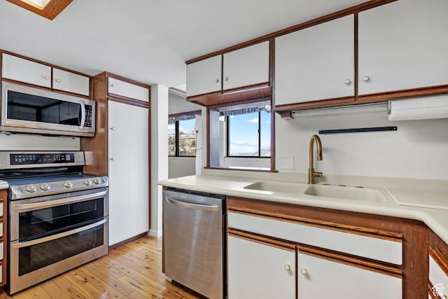 241 N Vine St W Unit 1101E, Salt Lake City, UT 84103 - kitchen featuring sink, stainless steel appliances, light hardwood / wood-style floors, and white cabinets