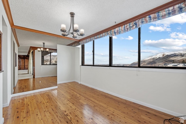 241 N Vine St W Unit 1101E, Salt Lake City, UT 84103 - spare room with wood-type flooring, a textured ceiling, and a notable chandelier
