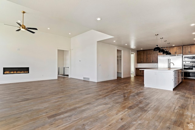434 W 450 S Unit 815, Farmington, UT 84025 - unfurnished living room with recessed lighting, wood finished floors, a glass covered fireplace, and a ceiling fan