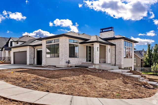 434 W 450 S Unit 815, Farmington, UT 84025 - view of front facade featuring an attached garage, driveway, stone siding, a chimney, and roof with shingles