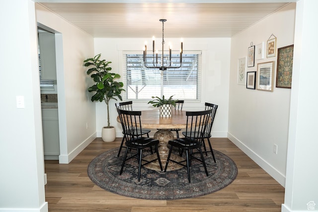 dining room with a chandelier, wood finished floors, and baseboards