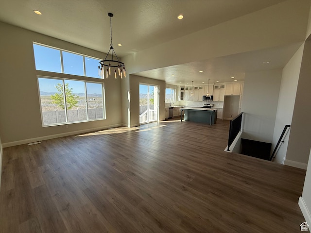 5523 N Honey Suckle Way, Eagle Mountain, UT 84005 - unfurnished living room featuring a chandelier, recessed lighting, dark wood finished floors, and baseboards