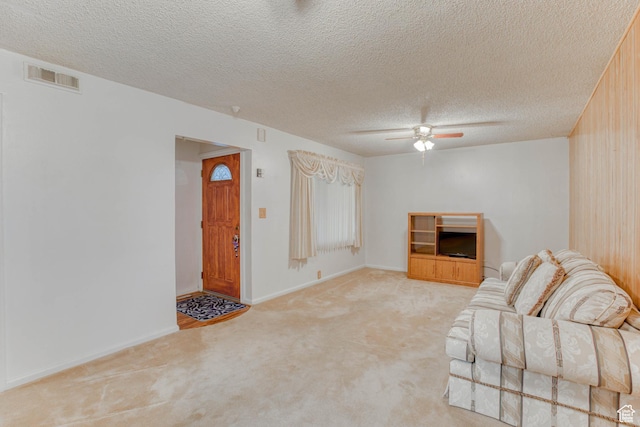 unfurnished living room featuring ceiling fan, light carpet, and a textured ceiling